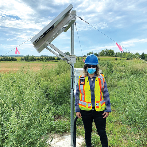 A person standing next to a micro-seismic monitoring station